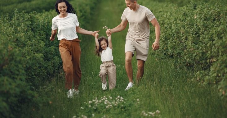 Joyful family enjoying a fun day outdoors in a green field, epitomizing togetherness and happiness.